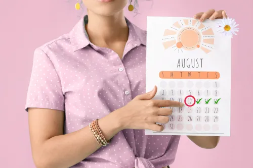 Woman holding a calendar with a circled date and checkmarks, symbolizing the return of a menstrual cycle and natural hormone balance.