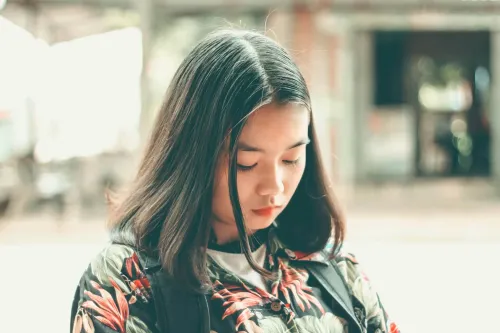 A concerned Asian woman experiencing PMDD symptoms, representing the emotional and physical challenges of premenstrual dysphoric disorder